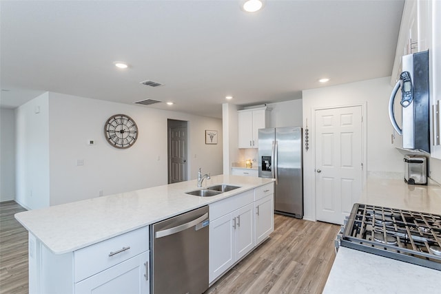 kitchen featuring a sink, white cabinetry, recessed lighting, light wood-style floors, and appliances with stainless steel finishes