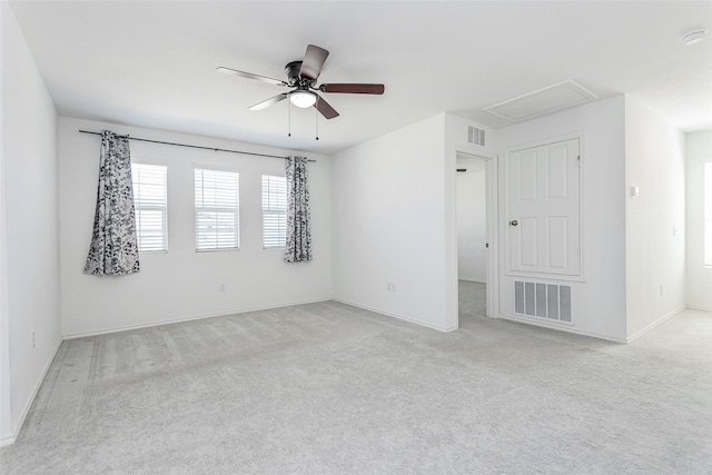 spare room featuring visible vents, light carpet, attic access, and ceiling fan