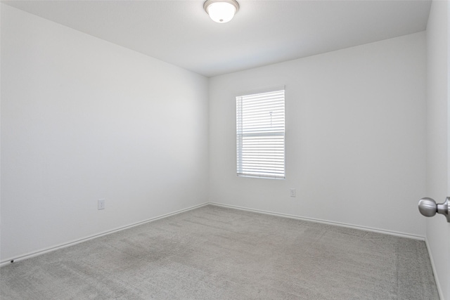 carpeted empty room with baseboards