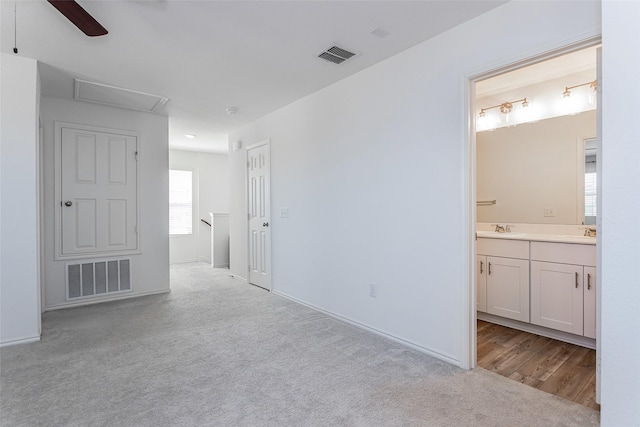 interior space with a sink, visible vents, carpet floors, and ensuite bathroom