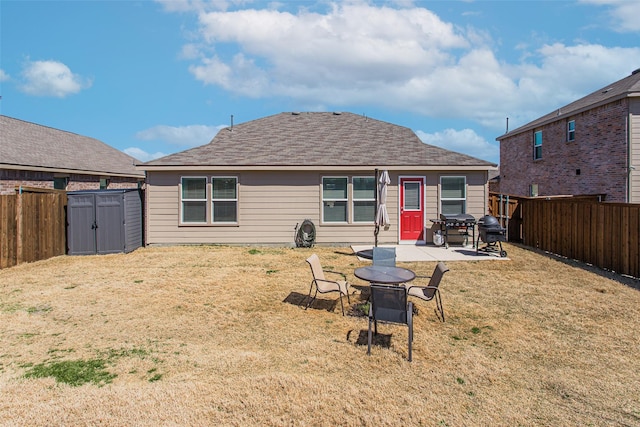 back of house with a patio, a fenced backyard, an outdoor structure, a storage shed, and a lawn