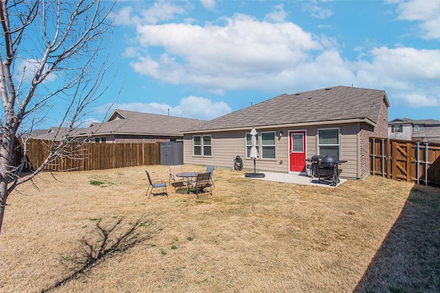 rear view of property with a patio, a yard, a fenced backyard, and a shingled roof