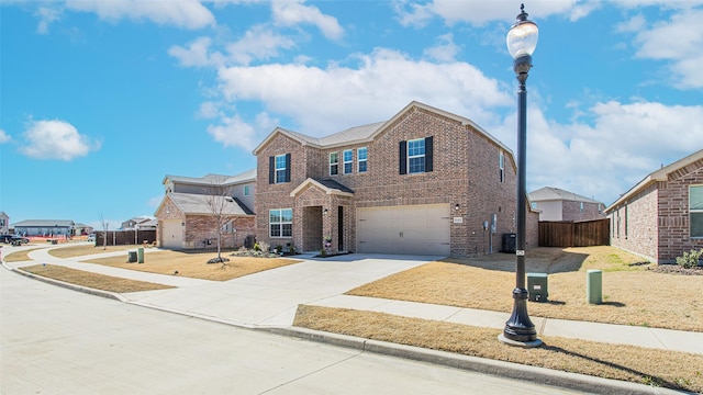 traditional-style house with brick siding, driveway, a garage, and fence