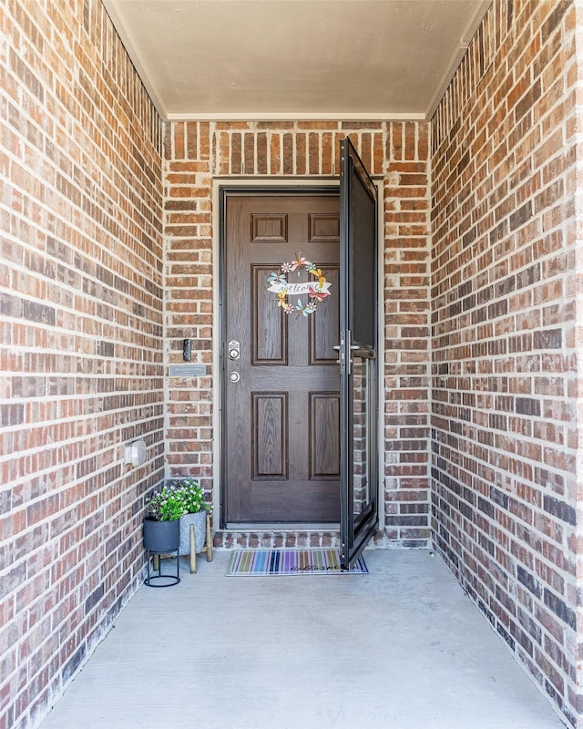 view of exterior entry with brick siding