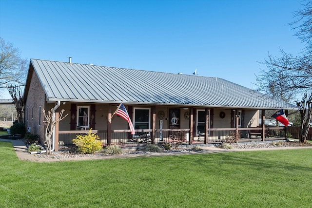 view of front of property with metal roof, a porch, a front yard, and a standing seam roof