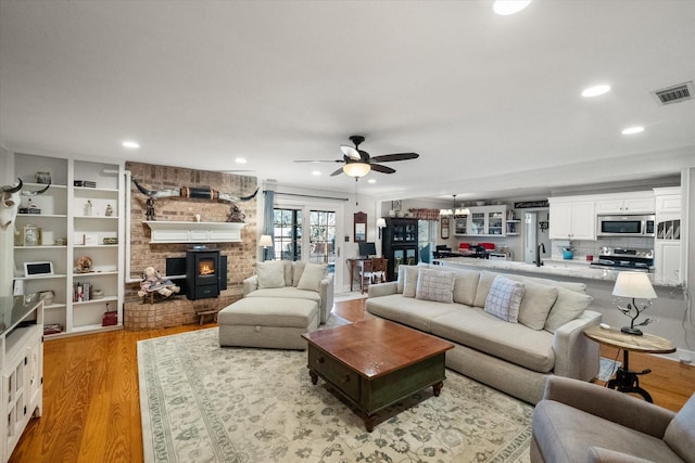 living room featuring visible vents, ceiling fan, light wood-type flooring, recessed lighting, and a fireplace