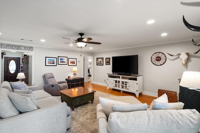 living room featuring a ceiling fan, recessed lighting, crown molding, light wood finished floors, and baseboards