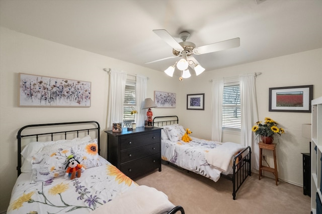 bedroom with multiple windows, light carpet, and a ceiling fan