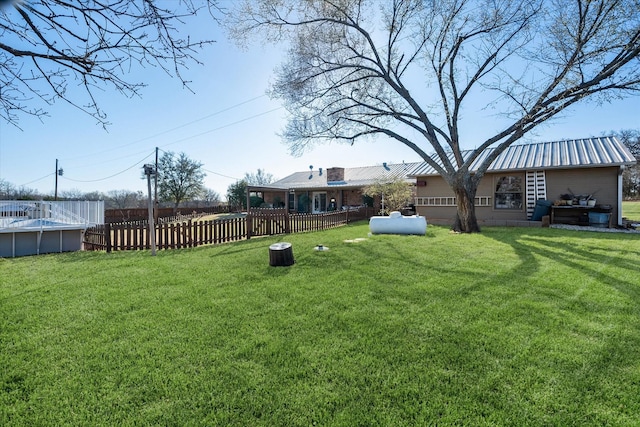 view of yard with fence and an outdoor pool