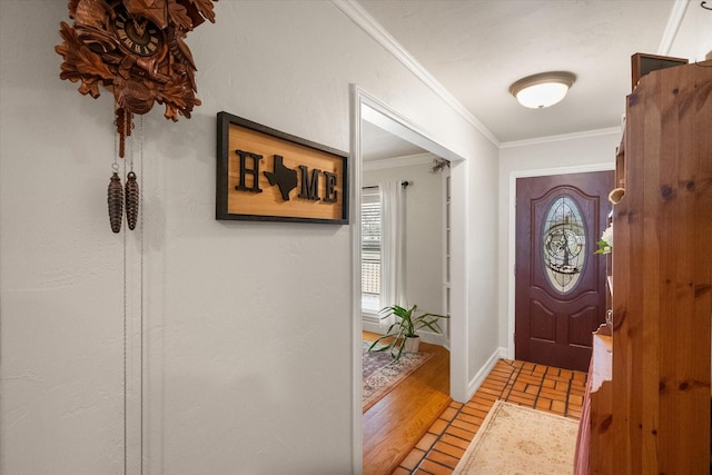 foyer with light wood-type flooring, baseboards, and crown molding