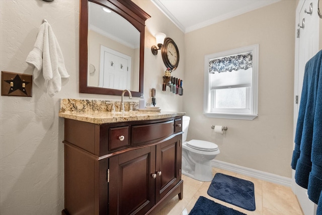 bathroom with vanity, baseboards, crown molding, toilet, and tile patterned floors