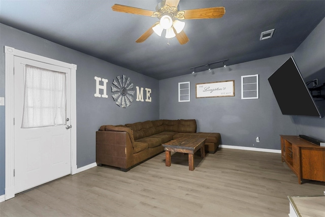 living room with visible vents, light wood-style flooring, track lighting, baseboards, and ceiling fan