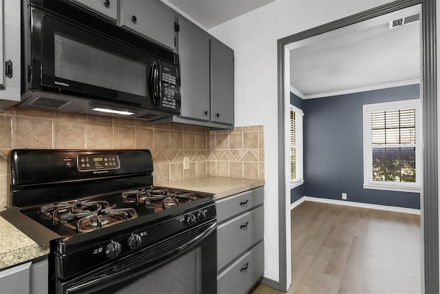 kitchen with backsplash, gray cabinetry, ornamental molding, light wood-style flooring, and black appliances