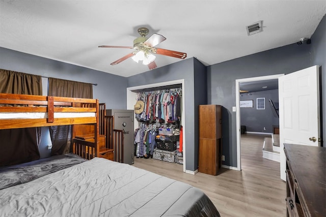 bedroom with visible vents, a closet, light wood finished floors, baseboards, and ceiling fan