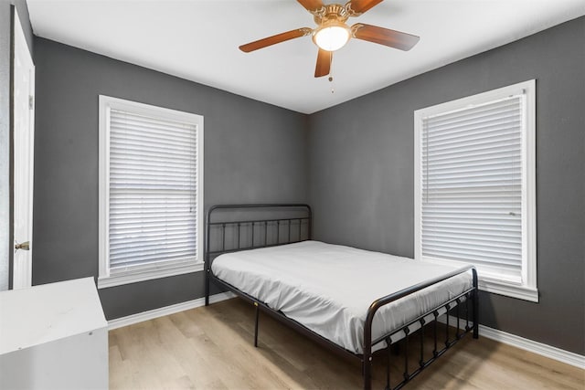 bedroom with wood finished floors, baseboards, and ceiling fan