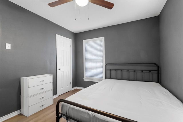 bedroom featuring baseboards, light wood-style floors, and ceiling fan