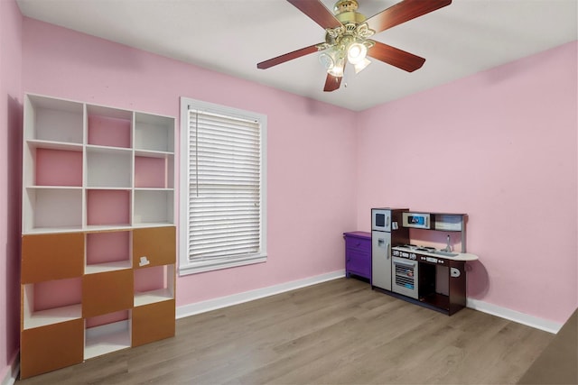 office area with light wood-style flooring, baseboards, and ceiling fan