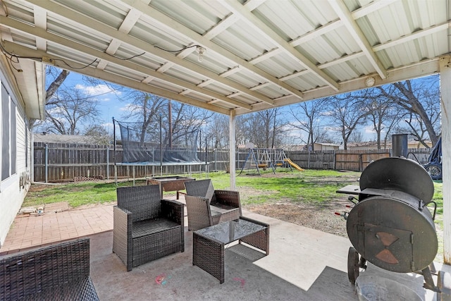 view of patio / terrace with a fenced backyard, area for grilling, a playground, and a trampoline