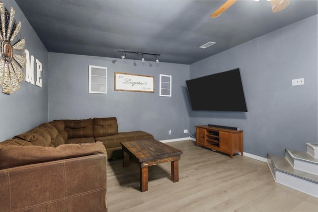 living area with a ceiling fan, visible vents, baseboards, and light wood finished floors