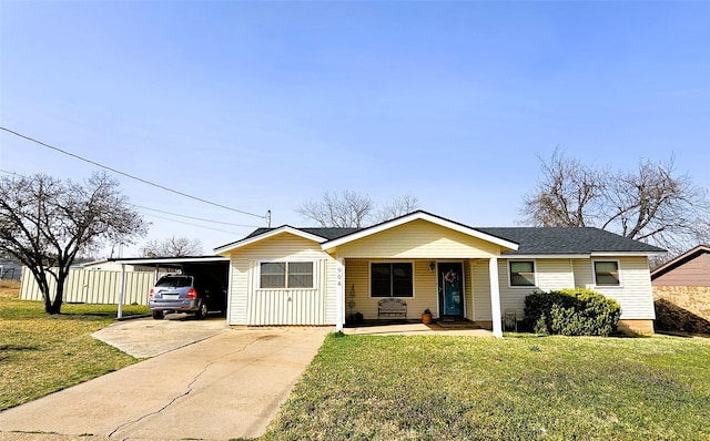 ranch-style house with an attached carport, a front yard, roof with shingles, covered porch, and concrete driveway