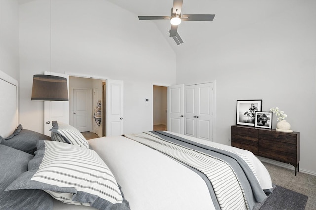 carpeted bedroom featuring a closet, baseboards, high vaulted ceiling, and a ceiling fan