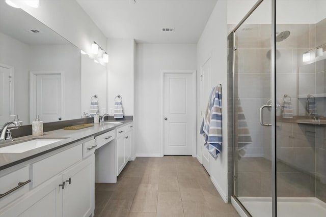 full bath featuring double vanity, visible vents, a stall shower, and a sink