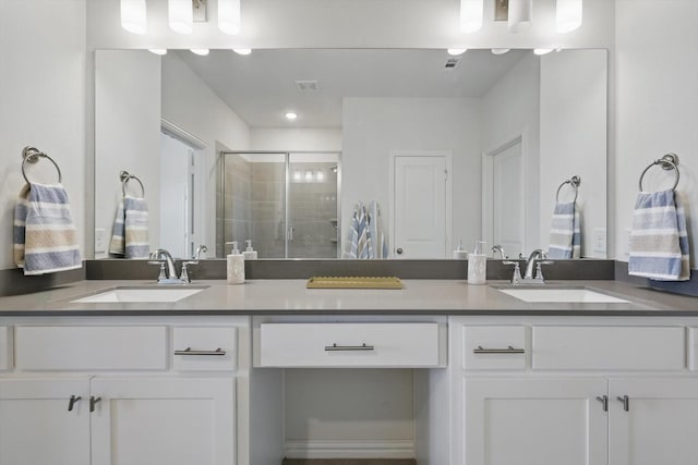 bathroom featuring double vanity, a stall shower, and a sink