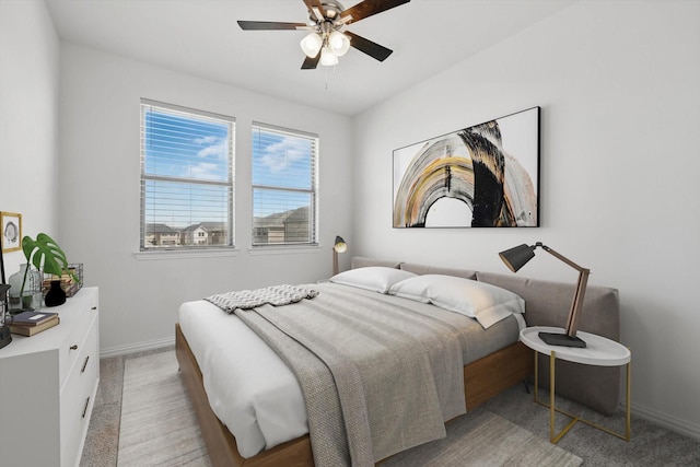 bedroom featuring baseboards, light carpet, and a ceiling fan