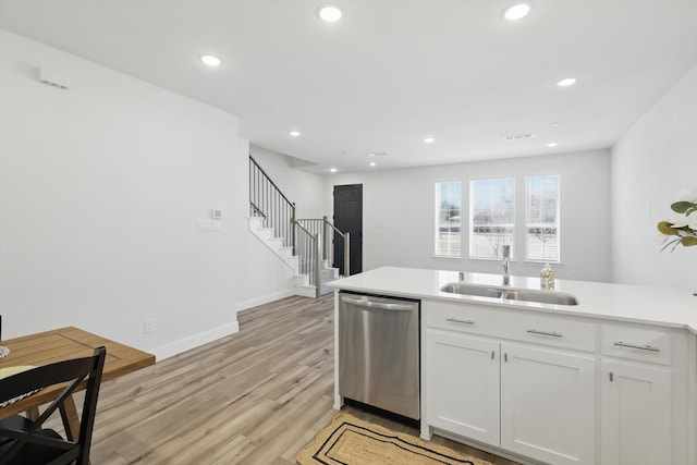 kitchen featuring light wood-type flooring, recessed lighting, stainless steel dishwasher, white cabinets, and a sink