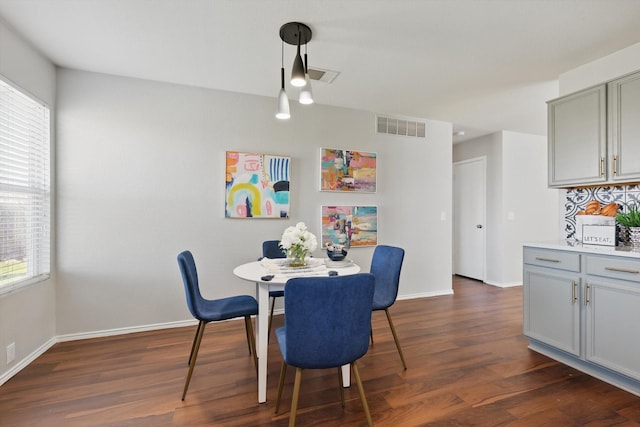 dining room with visible vents, dark wood-type flooring, and baseboards