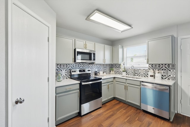 kitchen featuring a sink, light countertops, gray cabinetry, and stainless steel appliances