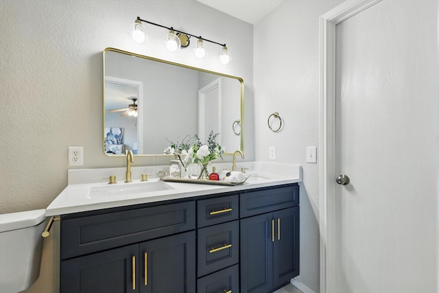 full bath featuring a sink, a ceiling fan, toilet, and double vanity