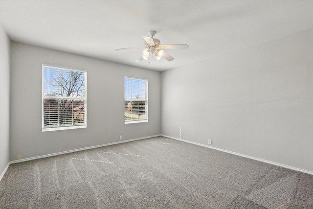 carpeted empty room featuring baseboards and a ceiling fan