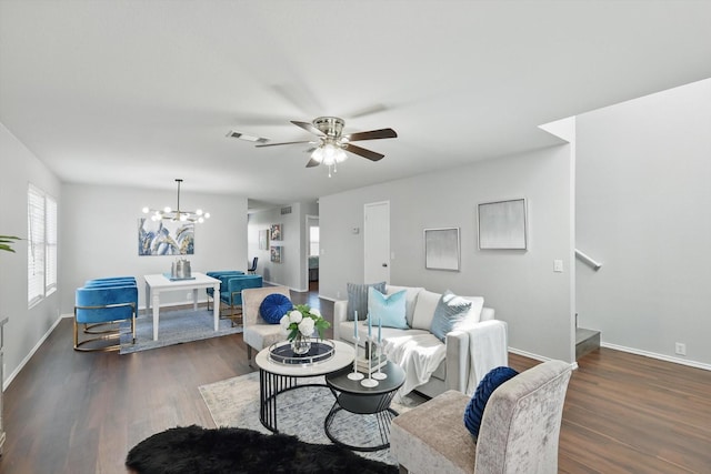 living room with visible vents, baseboards, wood finished floors, and ceiling fan with notable chandelier