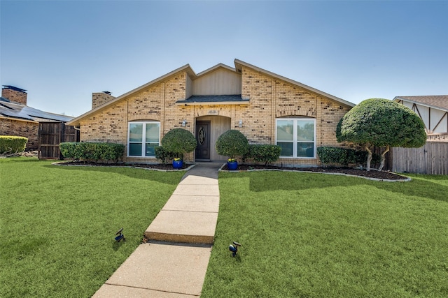 mid-century inspired home with a front lawn, fence, brick siding, and a chimney