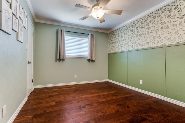 empty room with wood finished floors, baseboards, a wainscoted wall, ceiling fan, and crown molding