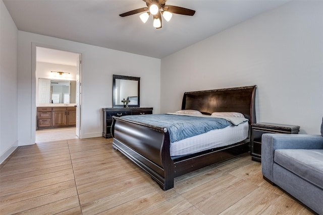 bedroom featuring connected bathroom, a ceiling fan, light wood-type flooring, and baseboards