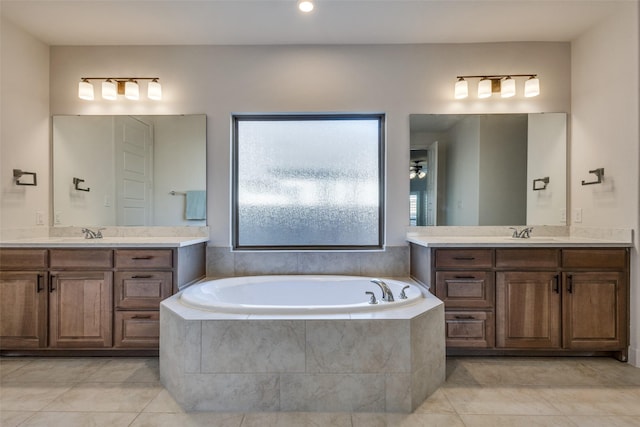 full bathroom featuring a garden tub, two vanities, tile patterned floors, and a sink