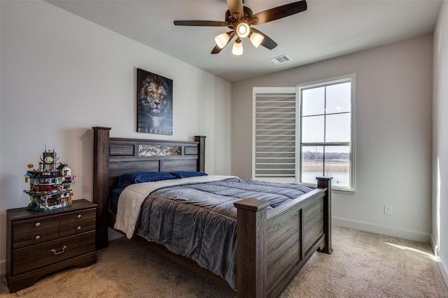 bedroom featuring visible vents, light colored carpet, a ceiling fan, and baseboards