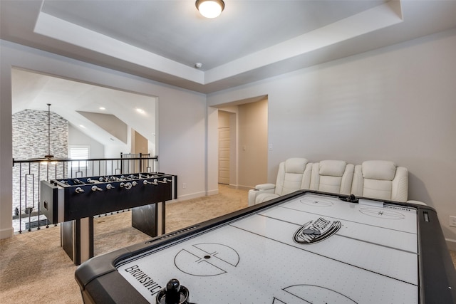 recreation room with a raised ceiling and carpet flooring