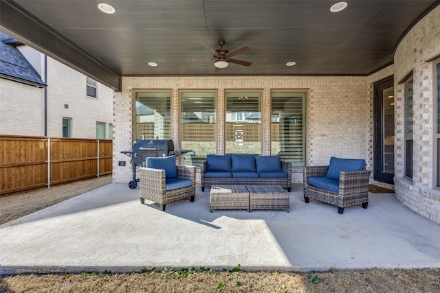 view of patio / terrace with area for grilling, an outdoor living space, ceiling fan, fence, and an outdoor kitchen