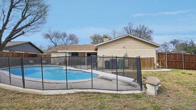 view of pool featuring a diving board, a yard, a fenced backyard, and a fenced in pool