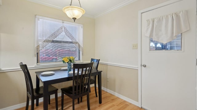 dining space with light wood-type flooring, baseboards, and crown molding