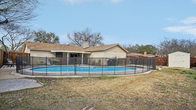 view of swimming pool with a fenced backyard, a fenced in pool, and an outdoor structure