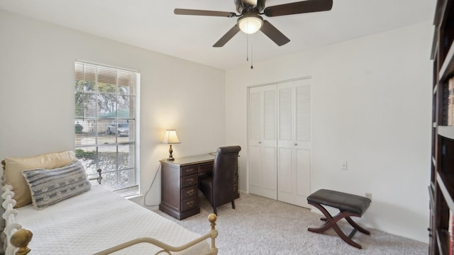 bedroom with a closet, light carpet, and a ceiling fan