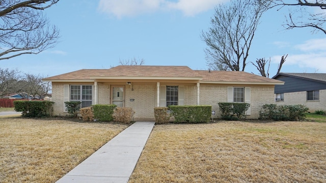 view of front of home featuring brick siding and a front lawn