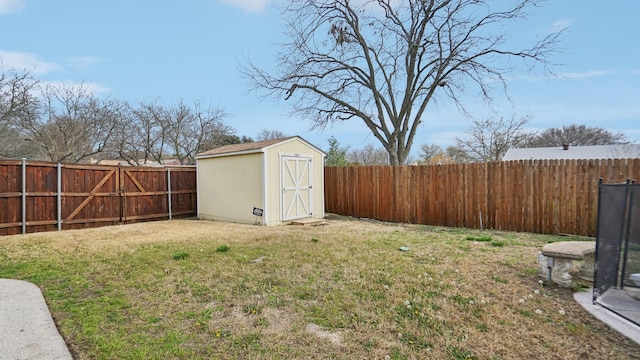 view of yard with a fenced backyard, an outbuilding, and a storage shed