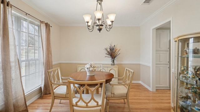 dining space with baseboards, visible vents, ornamental molding, a notable chandelier, and light wood-type flooring