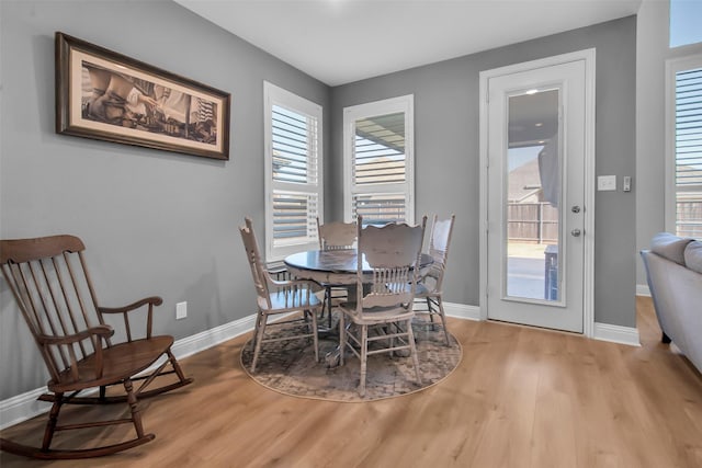 dining room featuring a wealth of natural light, baseboards, and wood finished floors