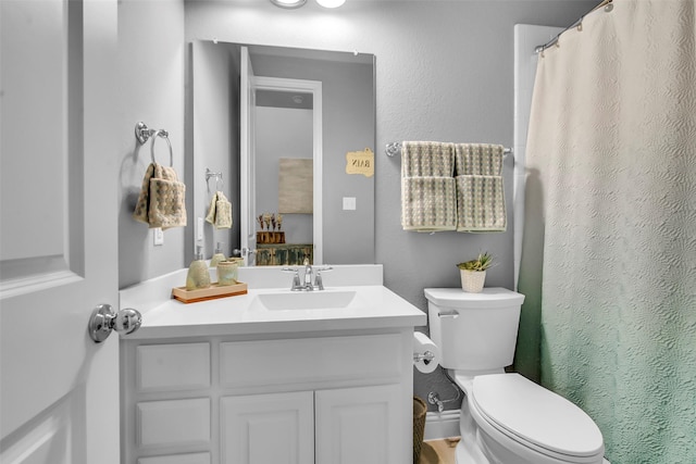 full bath with curtained shower, toilet, vanity, and a textured wall